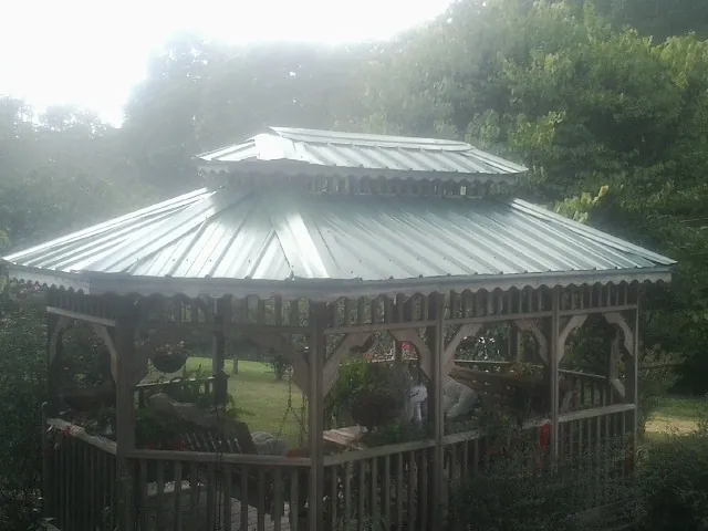 Two tier green metal roof on a garden gazebo in Berlin