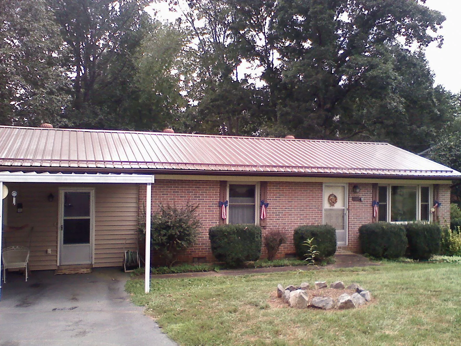 Bronze metal roof and carport on a brick ranch home — Roof Repair work by our crew in Berlin
